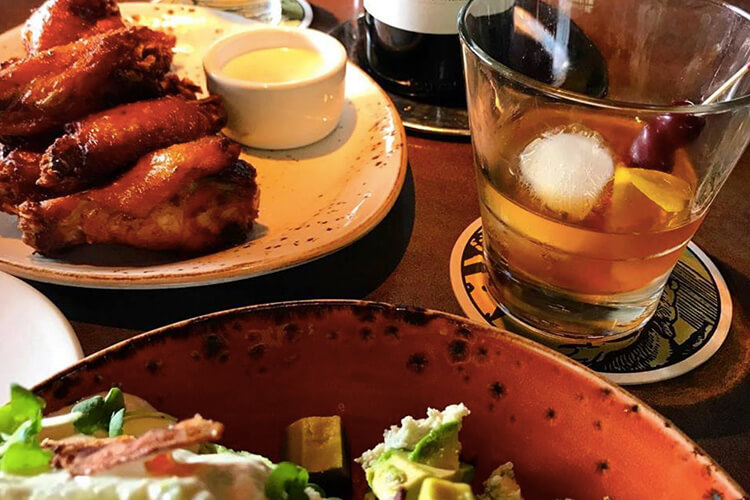 Wings, salad and Manhattan cocktail